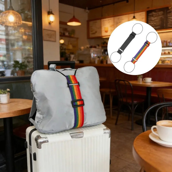 A grey fabric pillow rests on top of a white suitcase, with an inset showing a black and multi-colored nylon luggage strap.