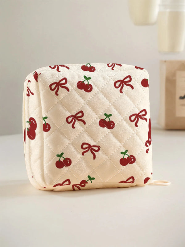 A cream quilted storage pouch featuring a red cherry and bow print.
