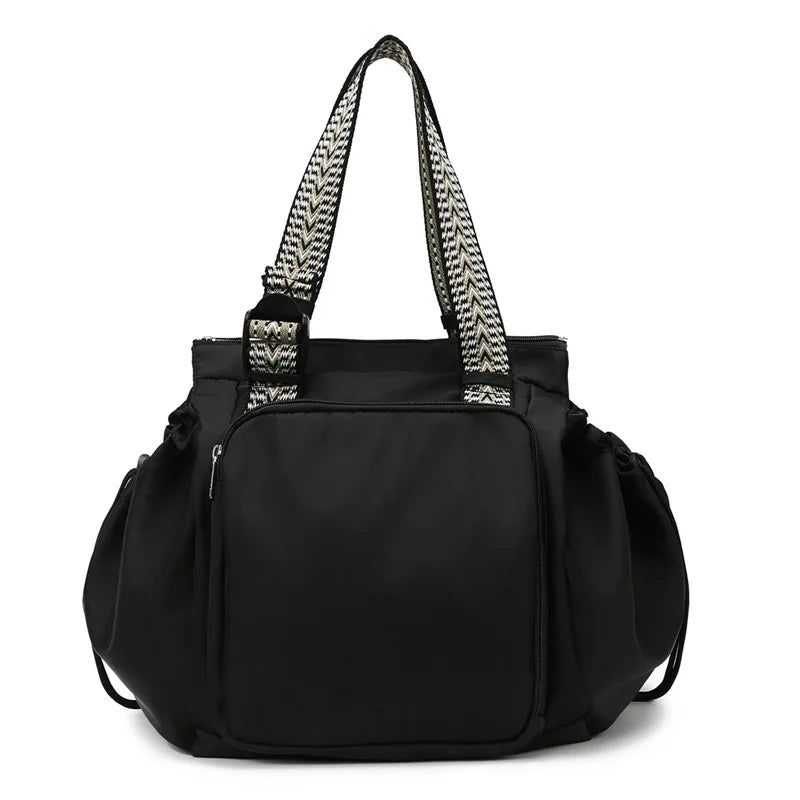 Black nylon shoulder bag with patterned straps and flap
