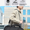 A person is carrying a large black travel duffel bag with multiple innovative features.