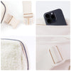 Ivory fleece crossbody belt bag featuring a light beige strap and a dark smartphone.