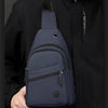 A navy blue lightweight nylon crossbody sling bag is shown being held by a person against a black jacket.