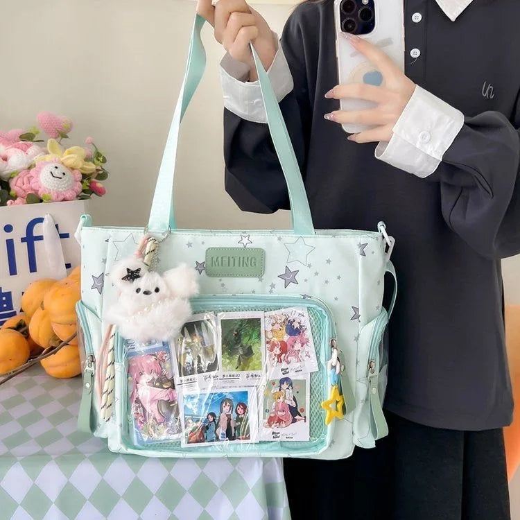 A person holds a light mint green transparent shoulder tote bag with a fluffy white charm against a light green checkered sur