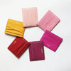 Une collection de porte-cartes en cuir véritable rose et magenta disposés en cercle.