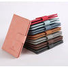 Une pile de porte-passeports et de portefeuilles pour cartes de crédit en cuir imperméable, dans diverses nuances de rouge, b