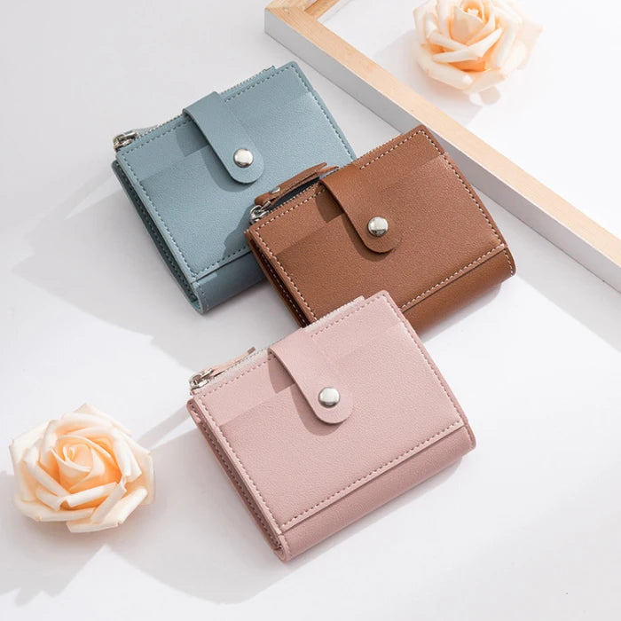 Three multi-color PU leather mini card holder wallets in mint green, brown, and pink resting on a white surface.