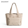 Sac fourre-tout rembourré beige matelassé avec poignées rembourrées sur fond blanc.