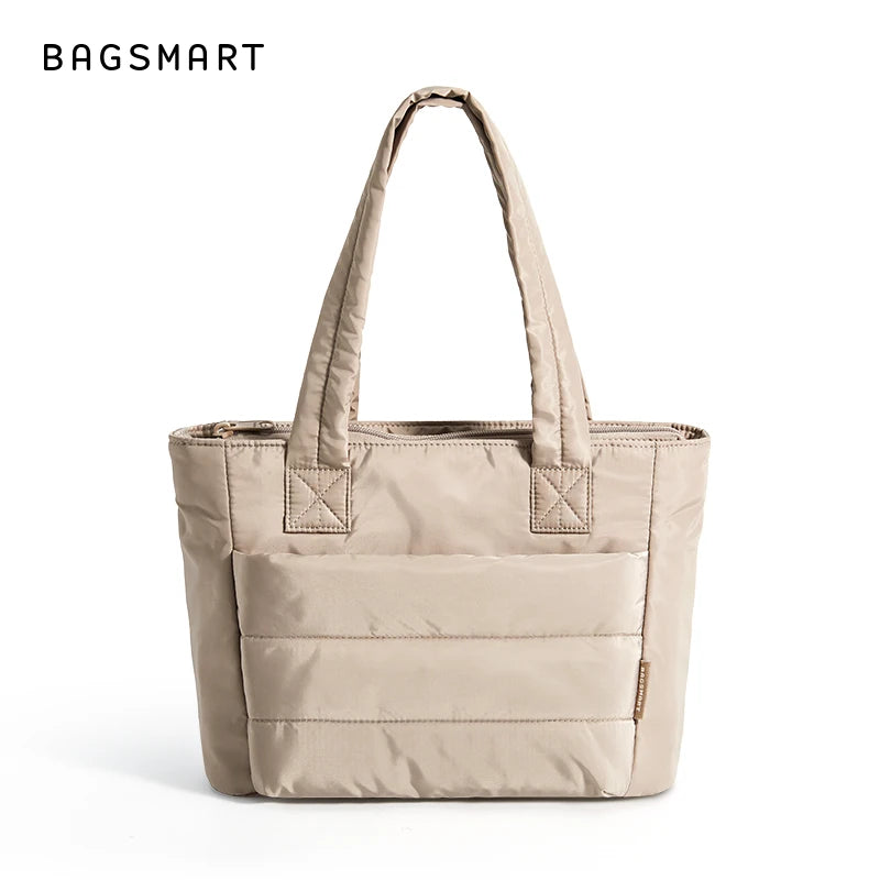 Sac fourre-tout rembourré beige matelassé avec poignées rembourrées sur fond blanc.