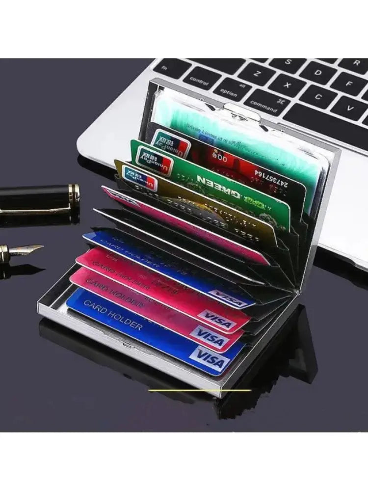 Un porte-cartes métallique fin à dix emplacements, ouvert, sur une surface noire à côté d'un clavier d'ordinateur portable.