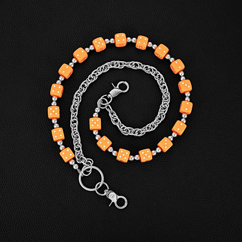 A silver chain necklace featuring square orange dice as charms, coiled in a circular pattern.