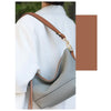 A light gray elegant PU leather detachable handbag with a brown strap shown from the back.
