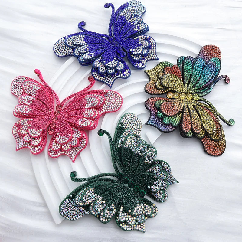 Four decorative rhinestone butterfly appliqués stickers in purple, pink, green, and multicolored hues on a white background