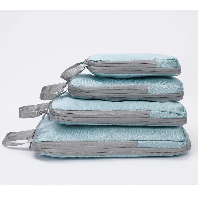 A set of four vertical travel organizer bags in light blue and gray fabric stacked together.