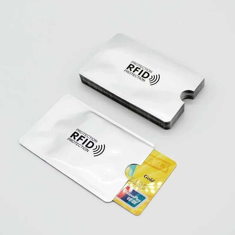 Una funda de tarjeta blanca con símbolo de protección RFID junto a una tarjeta amarilla.