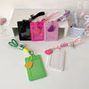 A collection of pink, green, and purple PU credit card and ID holder keychains with various colored cord attachments.