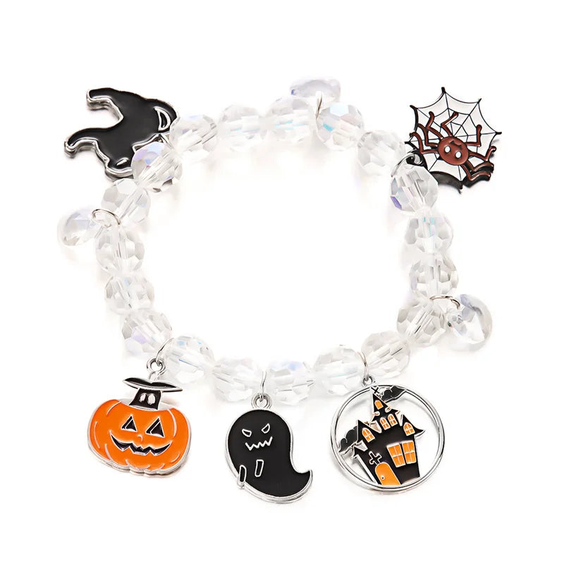 A bracelet featuring charms of a pumpkin, ghost, and spider on clear beads.