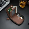 A brown retro PU leather men's wallet is open, showing cash and coins, resting on a dark surface next to a laptop.