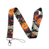 A patterned fabric lanyard featuring orange sun faces and floral designs on a dark blue background.