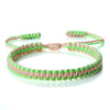 Handmade braided rope bracelet with pink and green threads, featuring an adjustable closure.