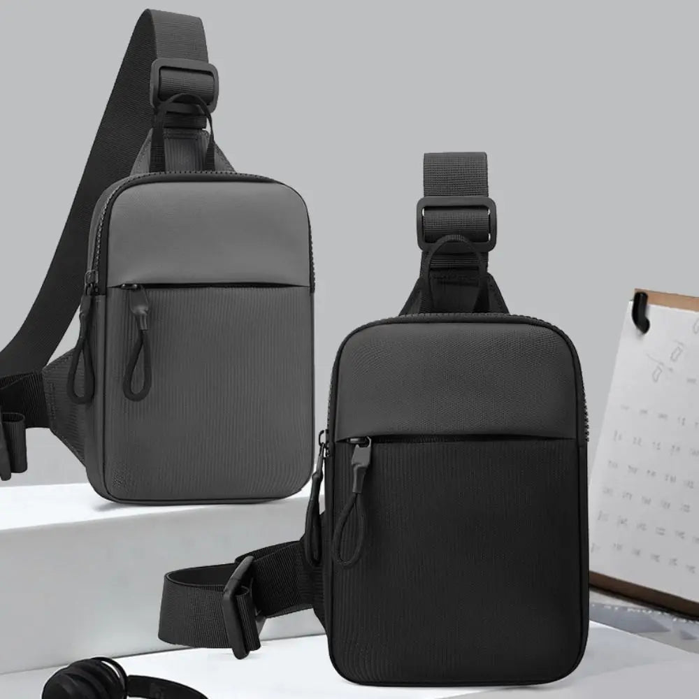 A black Oxford chest bag for men with a shoulder strap is shown against a light gray background.