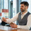 A man is holding a genuine leather RFID blocking card wallet in his hand.