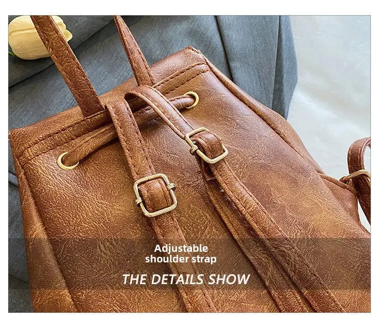 Gros plan d'un mini sac à dos en cuir marron rétro avec sangles réglables et détails de couture.