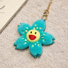 A bright turquoise sunflower plush keychain with yellow center and gold chain