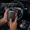 A hand holds a black and orange slim bifold wallet with RFID protection inside a car's dashboard.