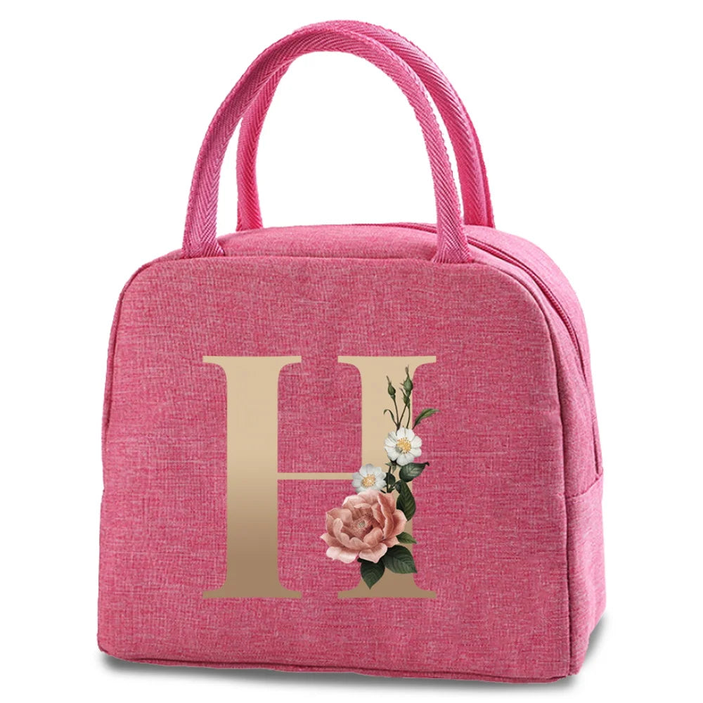 Pink insulated canvas lunch bag featuring a gold letter H and floral design