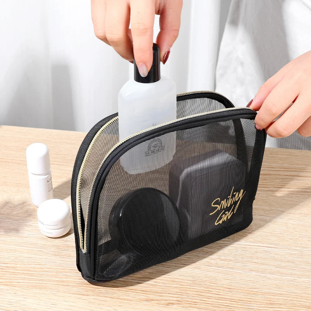 A hand is placing a white bottle into a black mesh travel cosmetic storage pouch.