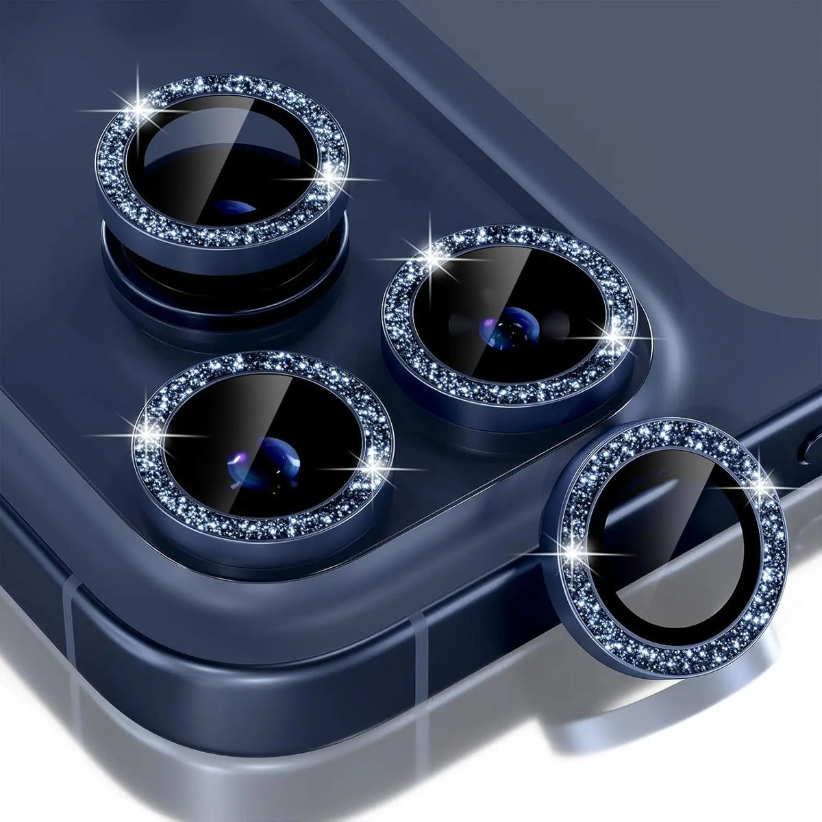 A close-up view of a dark blue camera lens protector with a metal frame and glitter diamond coating.