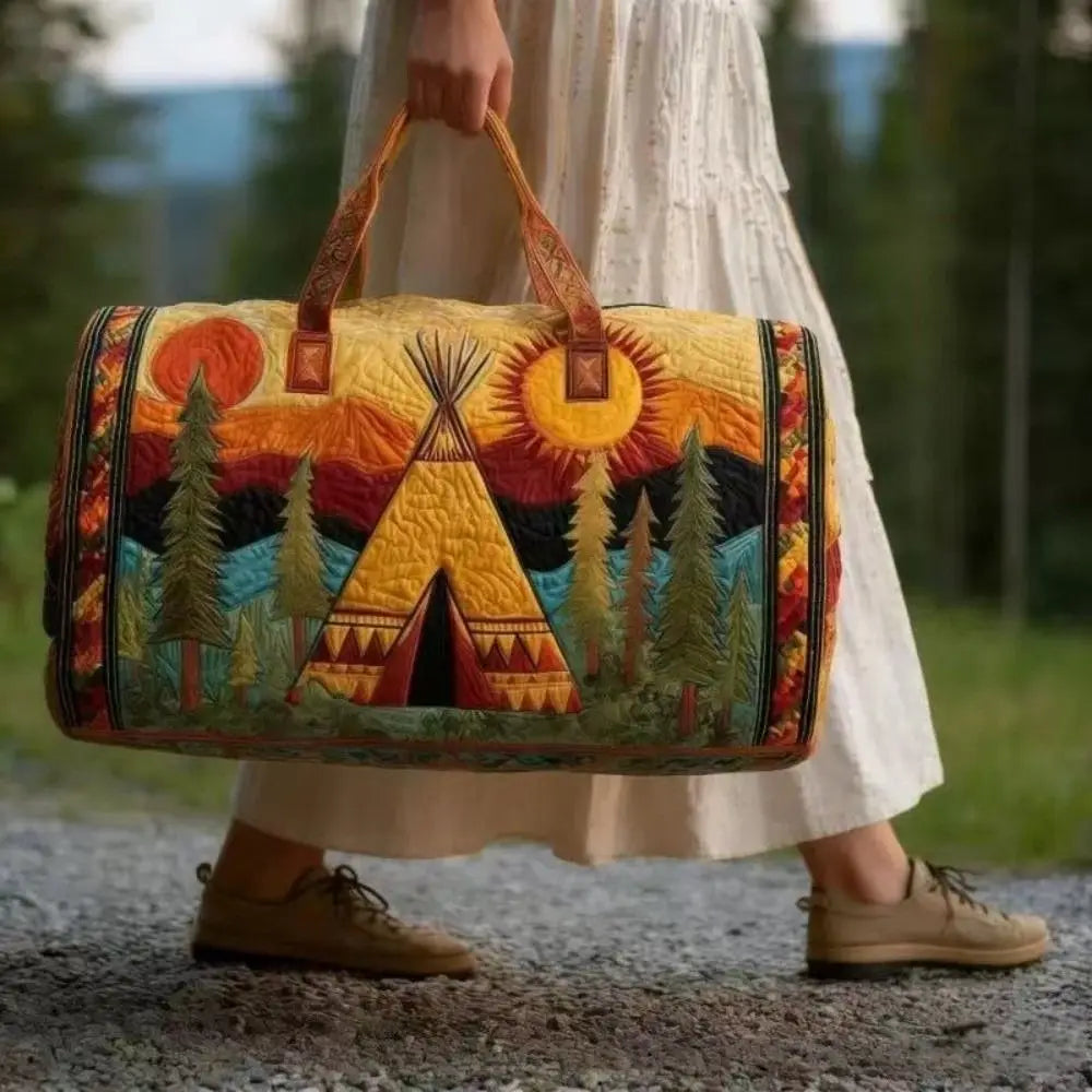 A woman holds a yellow quilted travel duffel bag with a geometric pattern against a blurred outdoor background.