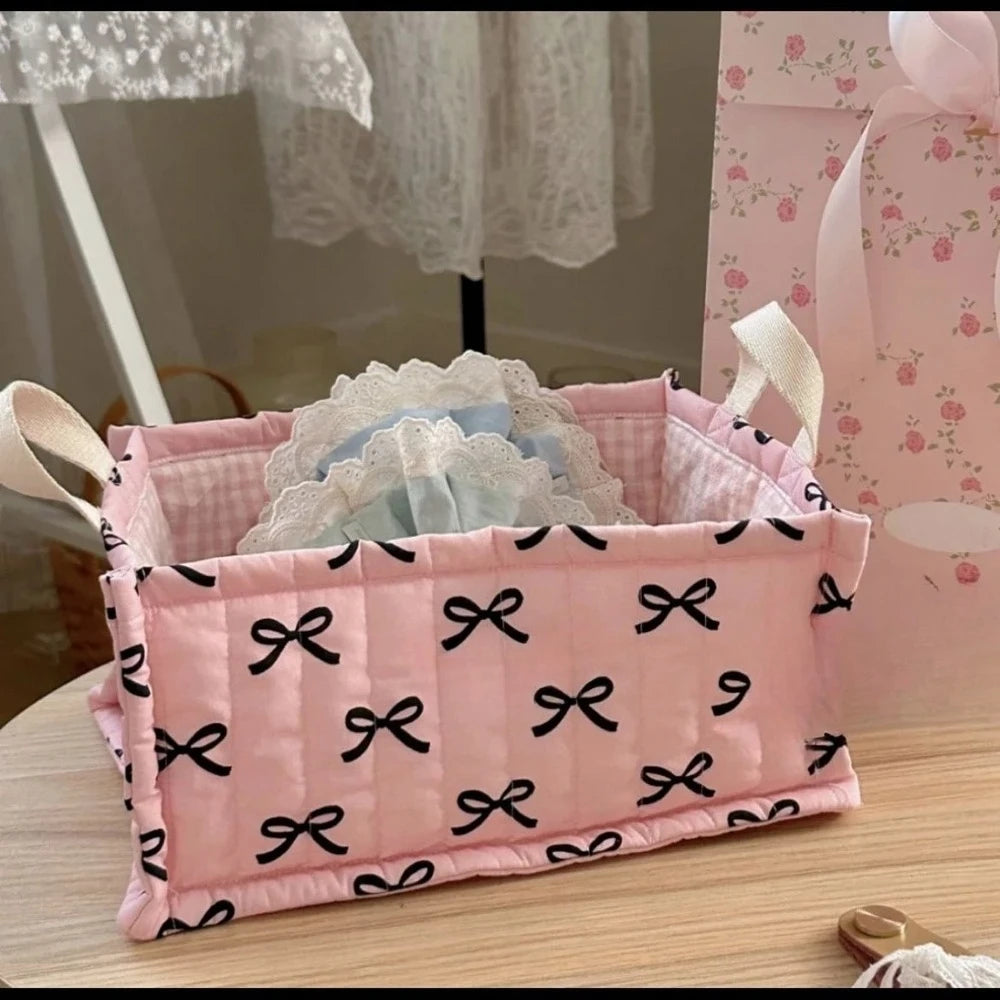 Pink quilted cotton storage basket with black bow pattern and lace flower design