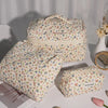 A set of quilted cotton makeup organizers in a floral pattern, including a large box and smaller pouches.