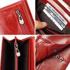 A close-up view of a red leather clutch wallet showing a zippered compartment and an identification card.