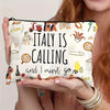 A hand holds a large capacity Italian souvenir makeup bag featuring text and illustrations.
