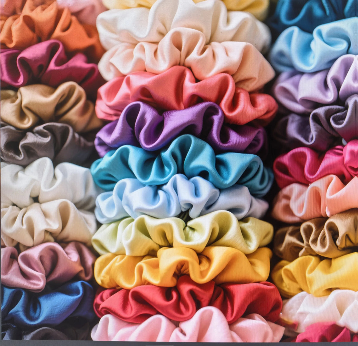 A collection of 19 thin scrunchies hair ties in various pastel and vibrant colors stacked together.