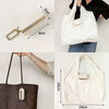 White cloth storage pouch with a leather keychain and a brown woven bag.