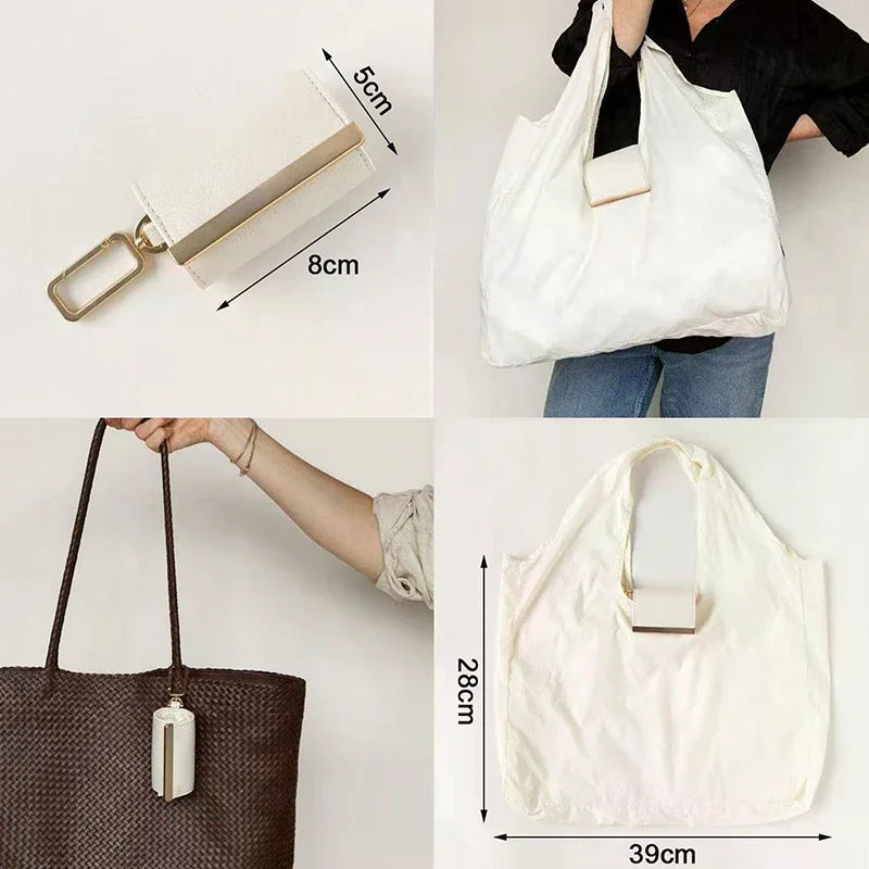 White cloth storage pouch with a leather keychain and a brown woven bag.