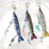 A set of fish-themed acrylic keychain charms featuring iridescent blue and green fish designs.