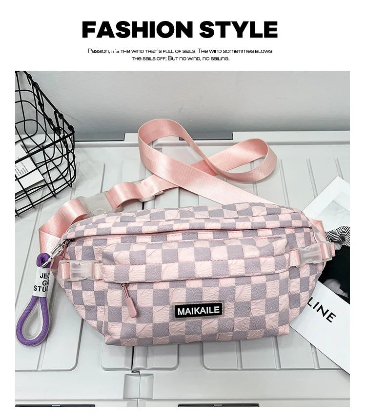 A pink plaid crossbody chest bag with a pink adjustable strap is displayed on a white surface.