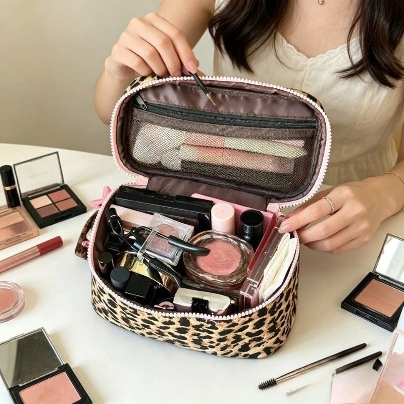 Bolso de maquillaje para viajar con estampado de leopardo rosa lleno de productos cosméticos.