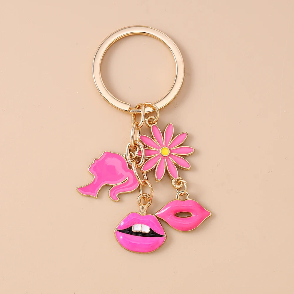 Gold-toned enamel keychain featuring a pink flower and pink lips on a gold ring.