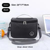 Black insulated portable lunch bag with a shoulder strap shown on a white surface.
