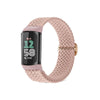 A light pink braided nylon watch band with a black and pink display module for a Fitbit device.