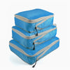 A set of three blue and gray reusable compression packing cubes.