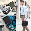 A man holds a black leather cable storage organizer bag in an outdoor setting.