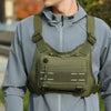 A person wearing a olive green tactical chest rig vest bag over a light blue hoodie.
