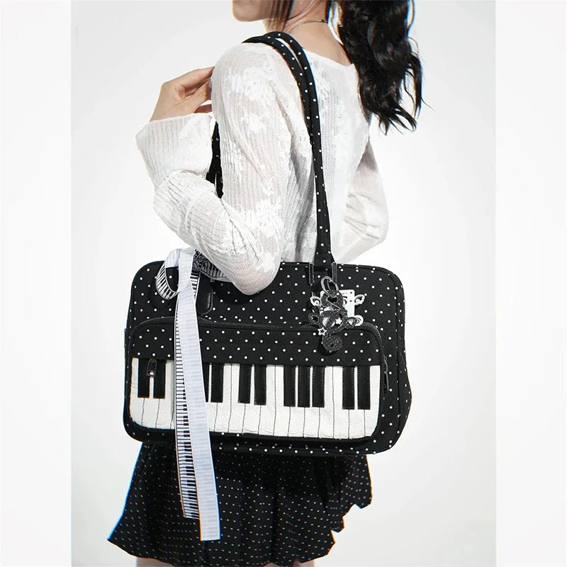 A woman is holding a black and white piano print crossbody bag with a white knit sweater and a black polka dot skirt.