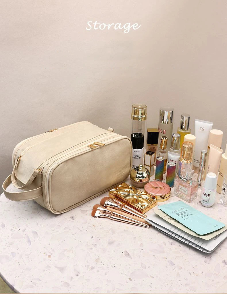 A beige PU leather travel makeup organizer with double zippers and various cosmetic bottles is displayed on a light surface.